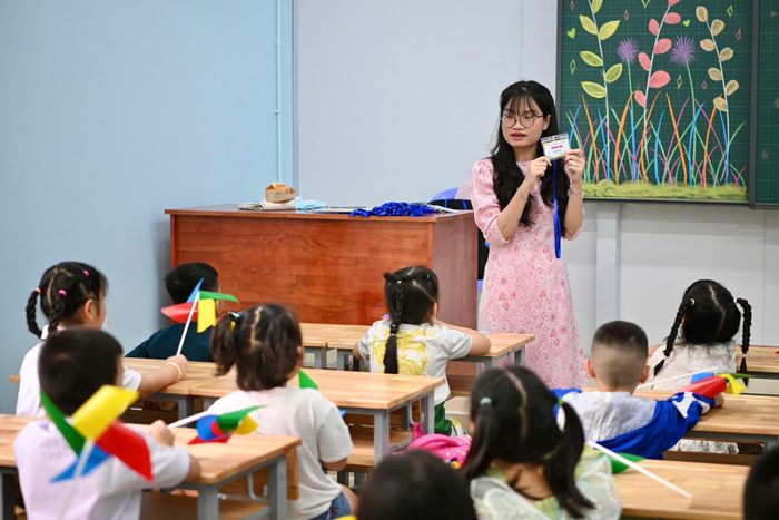  Tại lớp 1A4, cô Hồ Trần Thùy Linh hướng dẫn học sinh làm quen với chiếc thẻ tên ngay trong ngày đầu nhận lớp. Cô lần lượt gọi tên từng em, trao thẻ và dặn các con luôn đeo thẻ trong suốt thời gian ở trường. 