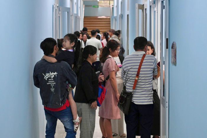  Đúng 7h30, các học sinh tập trung đông đủ ở lớp học. Trước cửa lớp, nhiều phụ huynh nán lại để quan sát từng phản ứng của con, có người còn tranh thủ chụp lại khoảnh khắc đầu tiên của con ở trường mới. Trong năm học đầu tiên, trường TH - THCS - THPT Lê Thị Riêng tuyển 140 học sinh. Các em được phân bổ về 4 lớp, mỗi lớp có sĩ số 35 học sinh. 