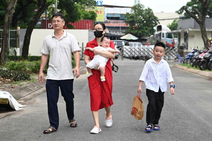  Anh Đoàn Thanh Khuê (phường Thới An) cùng vợ và con gái út mới 6 tháng tuổi đưa con trai lớn là Đoàn Huy Hoàng đến nhận lớp 1A3. Chia sẻ với Tri Thức - Znews về lý do chọn trường Lê Thị Riêng, anh Khuê cho biết trường cách nhà khoảng 2 km nên vợ chồng anh có thể thuận tiện đưa đón con. Khuôn viên trường rộng và có tổ chức bán trú cũng là một điểm cộng đối với gia đình. “Hơi hồi hộp một chút”, anh Khuê nói về cảm xúc khi con bước vào lớp 1. 