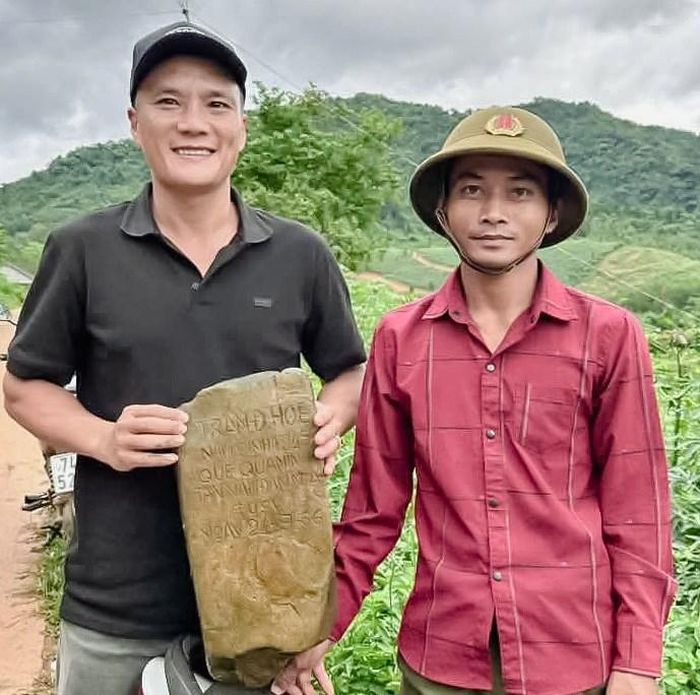 Thân nhân liệt sĩ Trần Đình Hòe (bìa trái) đón nhận tấm bia được người dân đưa ra từ rừng
