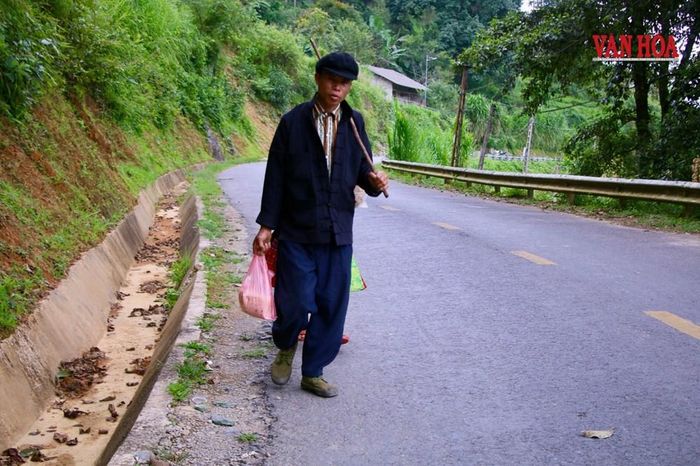 Hai vợ chồng đồng bào vùng cao rảo bước trên con đường từ chợ phiên về bản