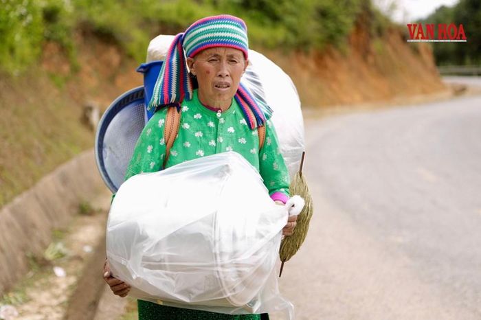 Bà Vàng Thị Chúa (54 tuổi) trên lưng nặng trĩu đồ vừa mua ở chợ phiên