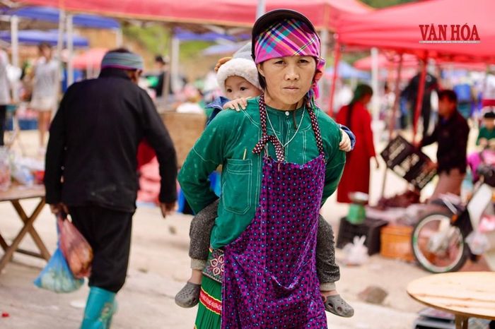 Những đứa trẻ nằm ngoan ngoãn trên lưng mẹ tại phiên chợ