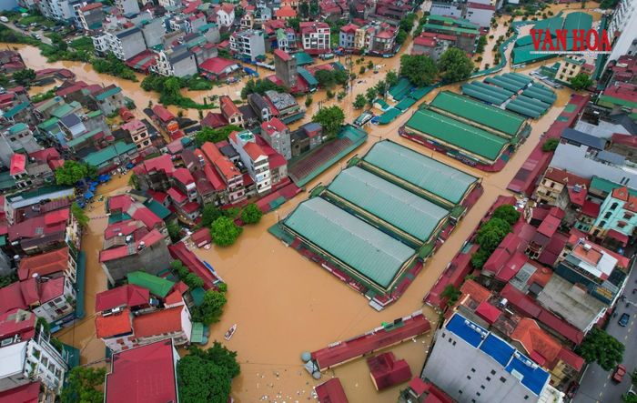 Từ trên cao, nhiều vùng ngập hiện lên thành những mảng nước lớn nối liền nhau, xen giữa là các tuyến đường, nhà dân và khu vực sản xuất bị nước bao phủ