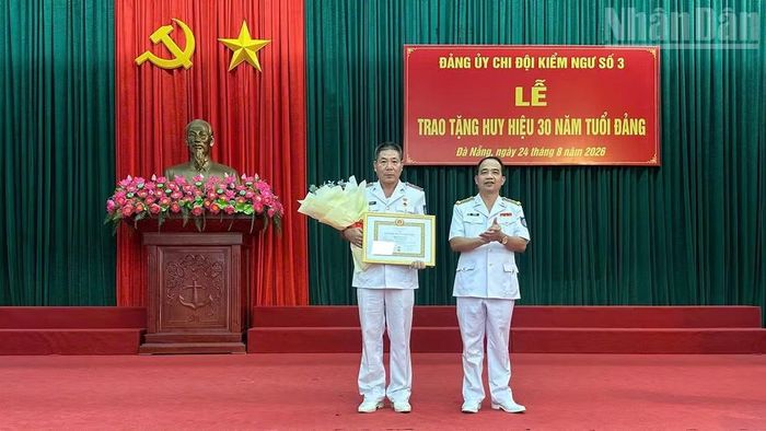 Trao tặng Huy hiệu 30 năm tuổi Đảng cho đảng viên Phan Văn Tân, Chi bộ Phòng Kỹ thuật. (Ảnh: NGUYỄN DŨNG)