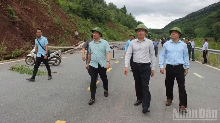 Thứ trưởng Lê Anh Tuấn (áo trắng, giữa) yêu cầu ngành xây dựng địa phương huy động mọi lực lượng tại chỗ để xử lý ngay và dứt điểm, trước mắt hót dọn các vị trí sạt lở, khôi phục hệ thống biển báo, bảo đảm an toàn giao thông. (Ảnh: THƯƠNG NGUYỄN)