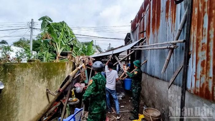 Cán bộ, chiến sĩ đồn Biên phòng Lai Hòa, Bộ đội Biên phòng thành phố Cần Thơ giúp dân khắc phục hậu quả lốc xoáy. (Ảnh: VĂN LONG)