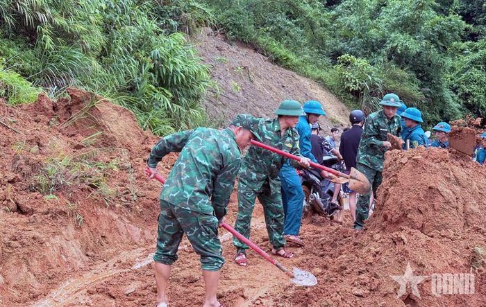 Cán bộ, chiến sĩ Đồn Biên phòng Trung Lý thu dọn đất đá, từng bước thông tuyến, bảo đảm an toàn cho người và phương tiện.