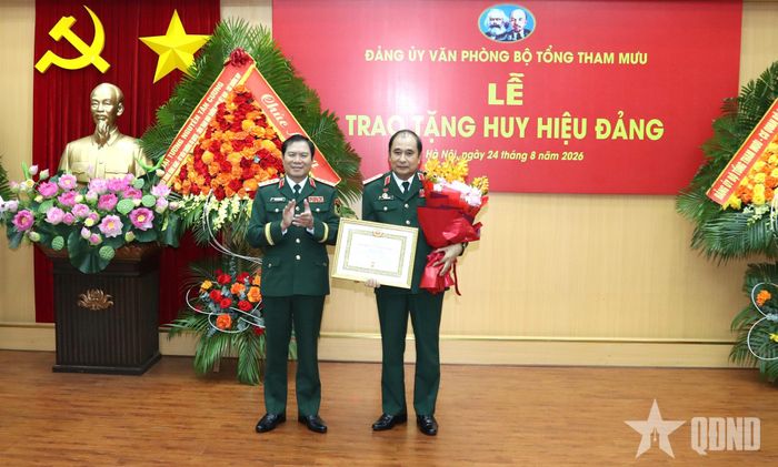 Đại tướng Nguyễn Tân Cương trao chứng nhận Huy hiệu 35 năm tuổi Đảng và hoa tặng Thượng tướng Phùng Sĩ Tấn.