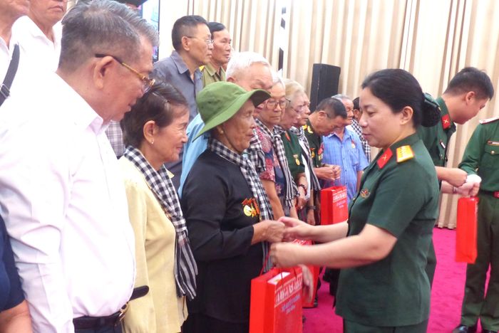 Đại tá Ngô Thị Lệ trao quà Bộ Quốc phòng tặng các đại biểu người có công với cách mạng TPHCM tại buổi gặp mặt. Ảnh: TRẦN BÌNH
