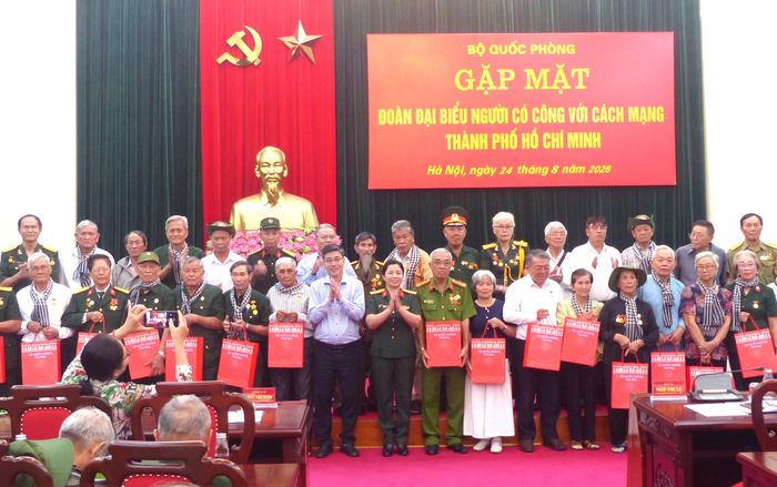 Trao quà Bộ Quốc phòng tặng các đại biểu người có công với cách mạng TPHCM tại buổi gặp mặt. Ảnh: TRẦN BÌNH
