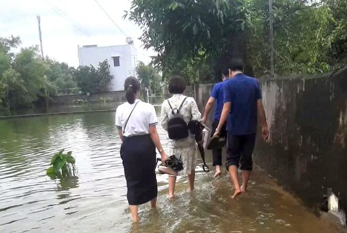 Dù đường ngập sâu do ảnh hưởng mưa bão nhưng không ngăn được bước chân thầy cô giáo đến với học trò.