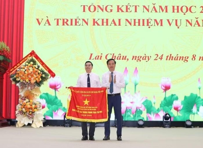 Ông Lê Đức Dục, Trưởng Ban Tuyên giáo và Dân vận Tỉnh ủy Lai Châu trao Cờ thi đua của Thủ tướng Chính phủ cho tập thể Trường THPT Than Uyên.