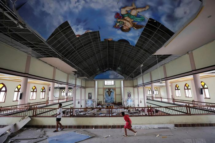 Các em nhỏ đứng trong nhà thờ St Fransiskus Asisi-Karot ở Ruteng, Indonesia bị hư hại nặng, sau trận động đất mạnh. Trận động đất 7,7 độ Richter xảy ra ngoài khơi đảo Flores (miền Đông Indonesia) vào sáng 15/8 làm rung chuyển khu vực, đã khiến ít nhất 70 người thiệt mạng, hơn 130 người bị thương. Indonesia đang tiếp tục đẩy mạnh cứu trợ trong bối cảnh hàng nghìn dư chấn vẫn xảy ra. Theo đó, chính phủ đã huy động máy bay, trực thăng, tàu hải quân và tàu bệnh viện để đưa hàng cứu trợ tới những khu vực bị cô lập, đồng thời phân phối hơn 250 tấn thực phẩm, nước uống, lều bạt và vật tư y tế cho người dân. Trong khi lực lượng cứu hộ tiếp tục rà soát các khu vực bị ảnh hưởng, Cơ quan Khí tượng, khí hậu và địa vật lý Indonesia (BMKG) cho biết đã ghi nhận hơn 2.700 dư chấn, trong đó trận mạnh nhất có độ lớn 6,2. Hoạt động địa chấn được dự báo có thể kéo dài 2-3 tuần trước khi ổn định, người dân sẽ tiếp tục phải đối mặt với những ngày bất an sau thảm họa. (Nguồn: CNN)