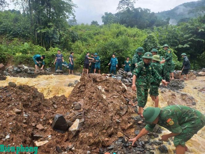 Cán bộ, chiến sĩ Đồn Biên phòng Trung Lý, Bộ đội Biên phòng tỉnh Thanh Hóa cùng các lực lượng chức năng khắc phục sự cố sạt lở đất trên quốc lộ 15C. Ảnh: Đơn vị cung cấp