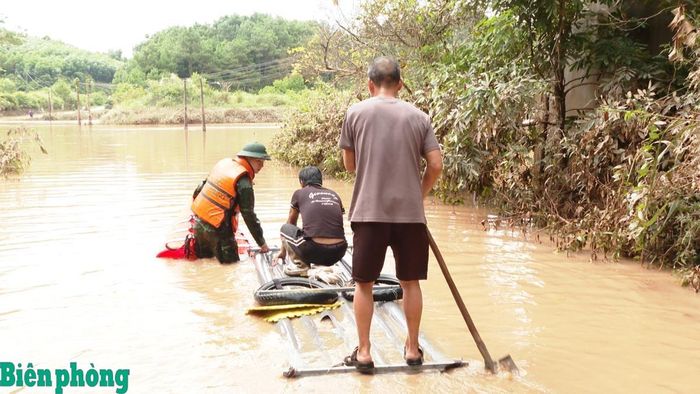 Cán bộ Đồn Biên phòng cửa khẩu Chi Ma, Bộ đội Biên phòng tỉnh Lạng Sơn hỗ trợ người dân tại khu vực bị ngập úng đi lại. Ảnh: Vi Toàn