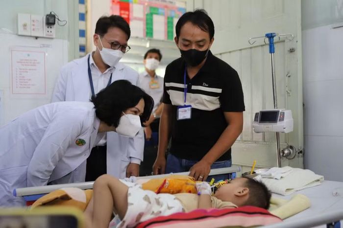 Thứ trưởng Bộ Y tế Nguyễn Thị Liên Hương hỏi thăm tình hình sức khỏe một bệnh nhi mắc tay chân miệng đang được điều trị tại Bệnh viện Nhi đồng 2 (TP HCM). Ảnh: Bộ Y tế