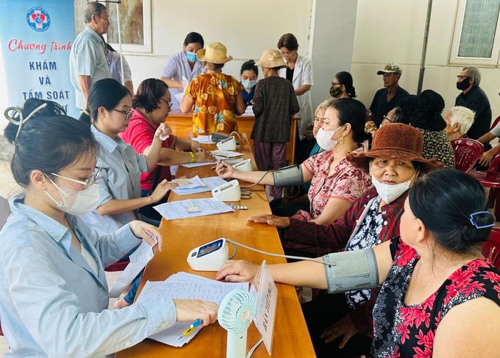 Các y, bác sĩ Bệnh viện Hùng Vương tư vấn, khám bệnh cho người dân tại phường Tiến Thành. Ảnh: Đức Định.