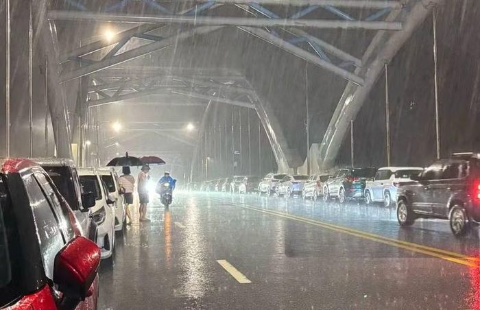  Người dân đánh xe lên cầu Bến Tượng để tránh ngập. ﻿Ảnh: Trần Hùng 