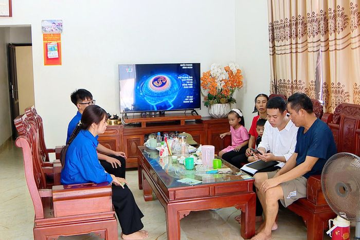 Anh Hoàng cùng thanh niên địa phương có những buổi tới tận nhà dân để hỗ trợ, hướng dẫn thủ tục hành chính. Ảnh: NVCC