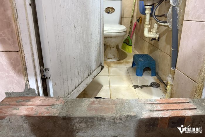 Hai hàng gạch mới được ông Ty xây để ngăn mưa ngập, nước trào từ nhà vệ sinh ra nhà. Ảnh: Kiều Oanh