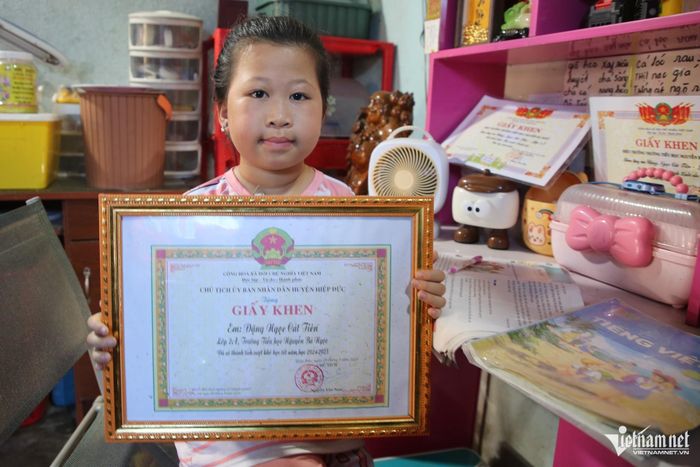 Cát Tiên nâng niu giấy khen - phần thưởng cho sự nỗ lực học tập dù em phải điều trị bệnh ung thư máu