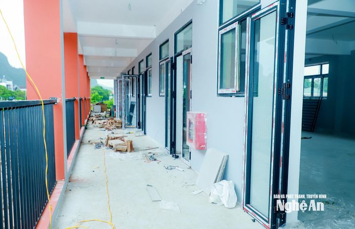 Nhà thầu đang đẩy nhanh lắp đặt cửa, hệ thống điện tại các phòng học của Trường Phổ thông Nội trú liên cấp Tiểu học và THCS xã Anh Sơn để chuẩn bị đón học sinh. Ảnh: Thành Duy