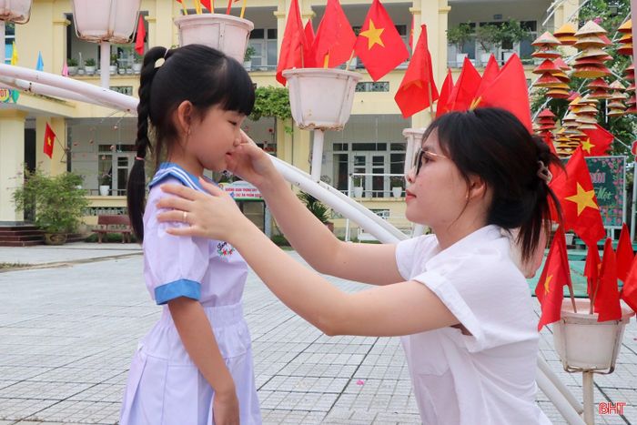 Phụ huynh chỉnh đốn trang phục cho con trước giờ vào lớp.