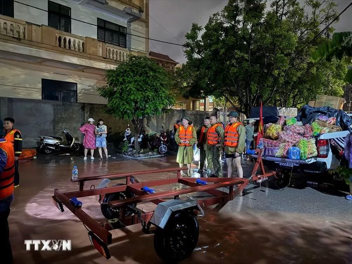 Các lực lượng chức năng chuẩn bị các phương án di dời dân vùng lũ. (Ảnh: Tiến Vĩnh/TTXVN)