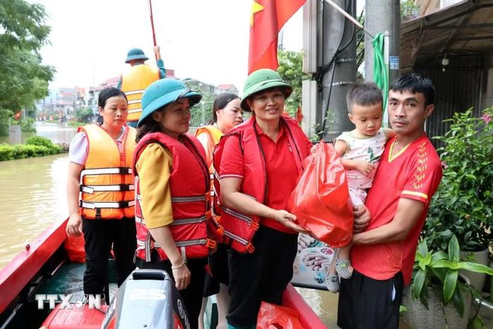 Bà Vũ Thị Quyên, Phó Chủ tịch Hội Chữ thập Đỏ tỉnh Lạng Sơn trao quà cho hộ dân có nhà bị ngập tại xã Thất Khê, tỉnh Lạng Sơn. (Ảnh: Văn Đạt/TTXVN)