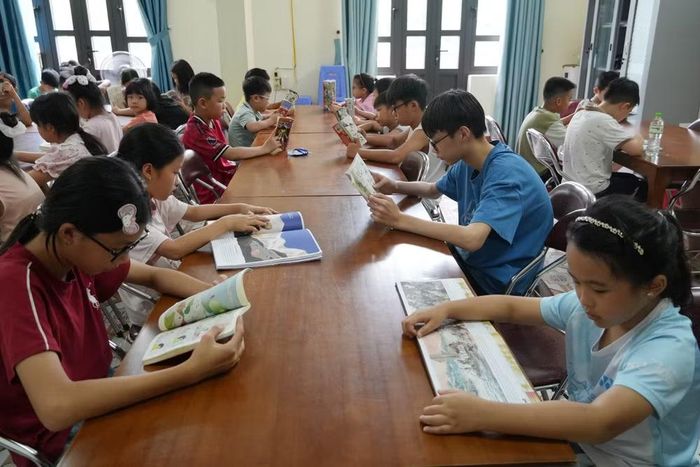 Học sinh được cán bộ thư viện giới thiệu các cuốn sách phù hợp với lứa tuổi. (Ảnh: Hải Yến/TTXVN)