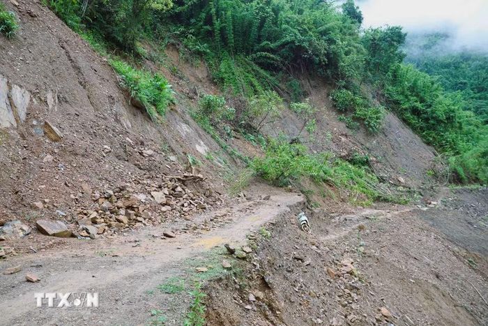 Điểm sạt lở, đứt gãy và sụt trượt mặt đường xuống sâu gần 2m, dài khoảng hơn 30m tại dốc Co Ngóa trên con đường độc đạo vào bản Na Ngân (xã Nga My, Nghệ An). (Ảnh: Xuân Tiến/TTXVN)