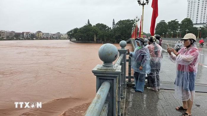 Bất chấp nguy hiểm, người dân livestream nước lũ trên cầu Kỳ Cùng (Lạng Sơn). (Ảnh: Quang Duy/TTXVN)