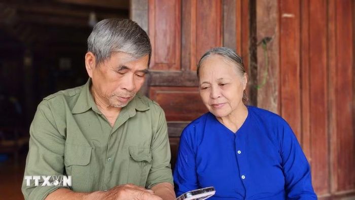 Ông Nông Đình Chiến và bà Dương Thị Hỷ, xóm Bản Um, xã Tam Kim, tỉnh Cao Bằng xem lại bức ảnh được chụp cùng Đại tướng Võ Nguyên Giáp. (Ảnh: Chu Hiệu/TTXVN)
