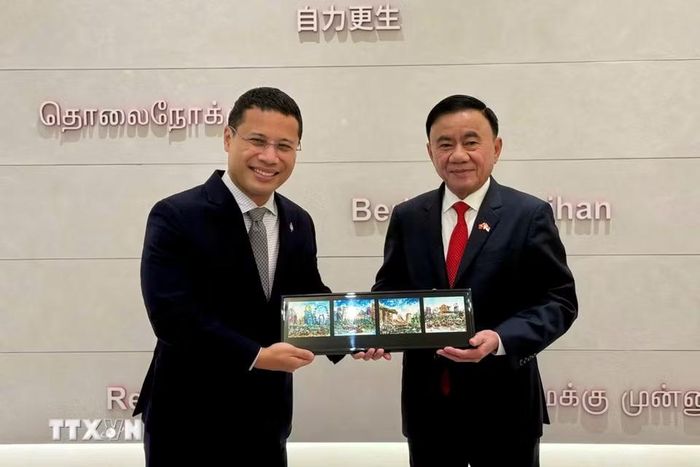 Ủy viên Bộ Chính trị, Thường trực Ban Bí thư Trần Cẩm Tú và Chủ tịch Đảng Hành động Nhân dân Singapore Desmond Lee trao tặng phẩm. (Ảnh: Phương Hoa/TTXVN)