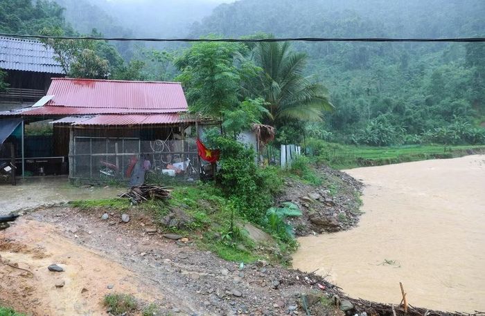 Suối Nậm Ngân dâng cao, dòng chảy mạnh khiến ngôi nhà bên suối có nguy cơ uy hiếp bởi sạt lở khu vực bờ suối cạnh hiên nhà. (Ảnh: Xuân Tiến/TTXVN)