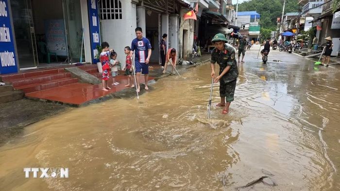 Lực lượng vũ trang hỗ trợ nhân dân dọn dẹp sau mưa lũ. (Ảnh: Quang Duy/TTXVN)