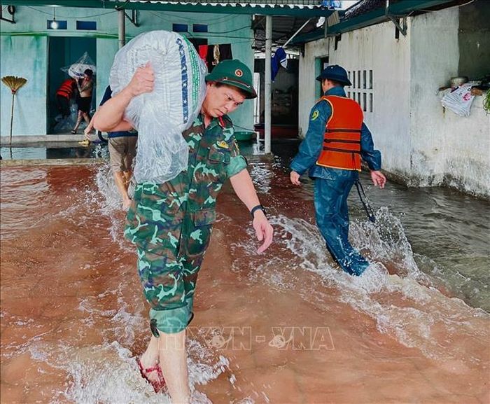 Cán bộ, chiến sĩ Bộ Chỉ huy quân sự tỉnh Bắc Ninh hỗ trợ người dân di dời tài sản tại xã Ngọc Thiện. Ảnh: Danh Lam/TTXVN