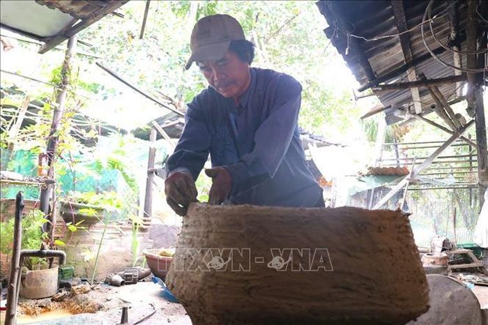 Ông Trần Dục tạo khuôn đất từ đất sét và trấu, sau đó nung chín khuôn để dùng làm dụng cụ đúc đồng.