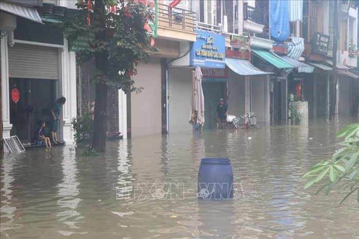 Người dân đặt các vật cản để cảnh báo phương tiện không đi vào khu vực ngập sâu trên phố Bùi Thị Cúc, phường Lê Thanh Nghị, thành phố Hải Phòng sáng 24/8. Ảnh: Mạnh Minh/TTXVN