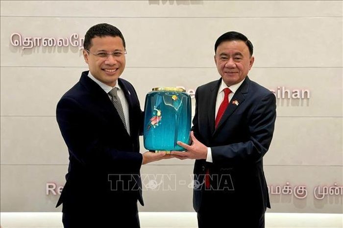 Ủy viên Bộ Chính trị, Thường trực Ban Bí thư Trần Cẩm Tú và Chủ tịch Đảng Hành động Nhân dân Singapore Desmond Lee trao tặng phẩm. Ảnh: Phương Hoa/TTXVN