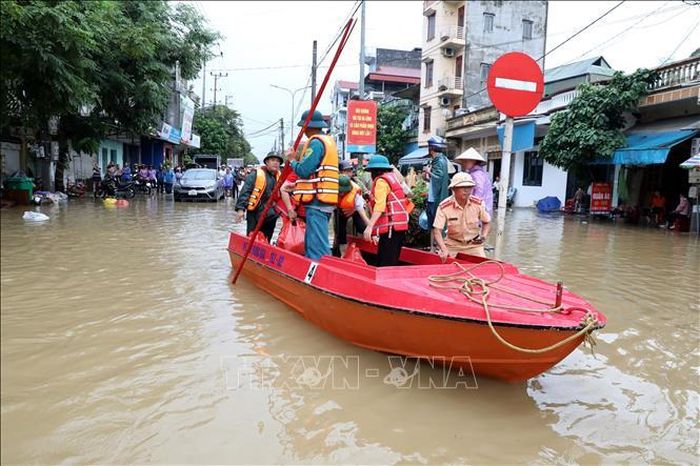 Lực lượng chức năng xã Thất Khê, tỉnh Lạng Sơn thường trực tại các điểm ngập sâu trên Quốc lộ 4A để hỗ trợ nhân dân. Ảnh: Văn Đạt/TTXVN
