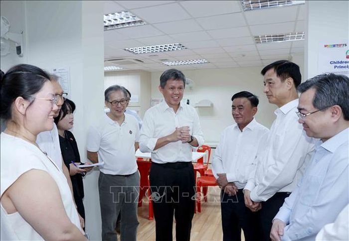 Phó Tổng Thư ký Đảng Hành động Nhân dân, Bộ trưởng Quốc phòng kiêm Bộ trưởng Điều phối dịch vụ công Chan Chun Sing (giữa) giới thiệu địa điểm tiếp xúc cử tri của Đảng Hành động Nhân dân Singapore (giữa) với đồng chí Trần Cẩm Tú và thành viên đoàn Việt Nam. Ảnh: Phương Hoa/TTXVN