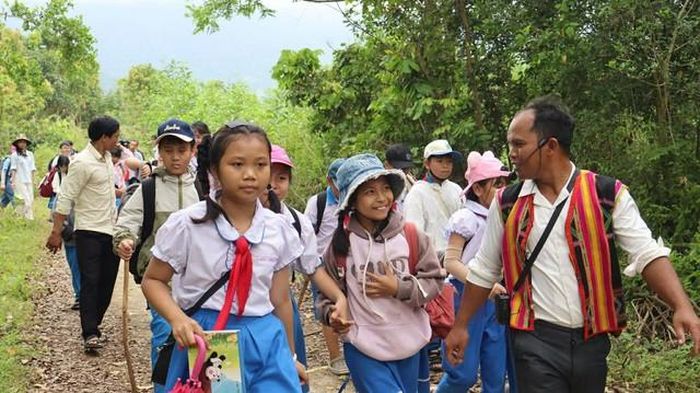 Đinh Ri - ngoài cùng bên phải ảnh dẫn tour cho các em nhỏ tới tham quan làng Vĩnh An. Ảnh: Đinh Ri