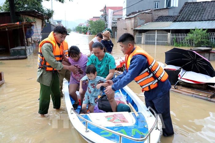 Lực lượng chức năng xã Tràng Định, tỉnh Lạng Sơn hỗ trợ đưa người dân từ vùng ngập sâu đến nơi an toàn. Ảnh: Văn Đạt - TTXVN