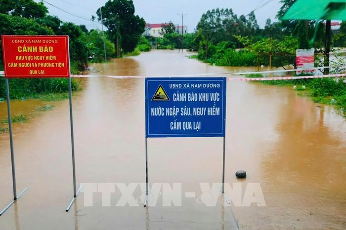 Lực lượng chức năng đặt biển cảnh báo tại các khu vực bị ngập, chia cắt do nước lũ. Ảnh: Đồng Thúy - TTXVN 