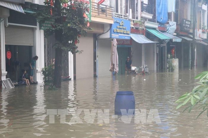 Người dân đặt các vật cản để cảnh báo phương tiện không đi vào khu vực ngập sâu trên phố Bùi Thị Cúc, phường Lê Thanh Nghị, thành phố Hải Phòng sáng 24/8. Ảnh: Mạnh Minh - TTXVN