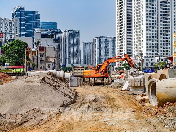 Công nhân vận hành máy xúc, thi công hệ thống hạ tầng trên tuyến đường Vành đai 2,5 qua phường Xuân Đỉnh. Ảnh: Trung Nguyên - TTXVN