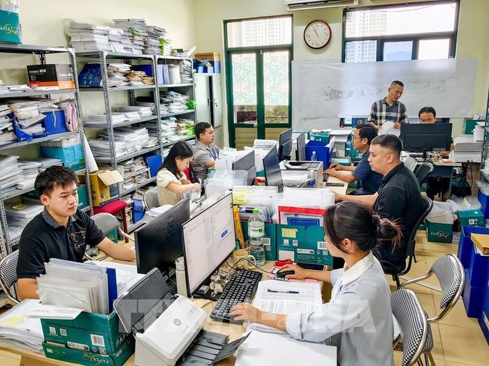 Cán bộ Ban Quản lý dự án đầu tư hạ tầng phường Xuân Đỉnh rà soát hồ sơ, phương án bồi thường, hỗ trợ và tái định cư phục vụ giải phóng mặt bằng các dự án trọng điểm trên địa bàn. Ảnh: Trung Nguyên - TTXVN
