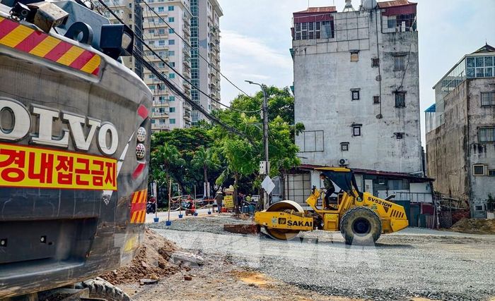 Công nhân vận hành máy xúc, thi công hệ thống hạ tầng trên tuyến đường Vành đai 2,5 qua phường Xuân Đỉnh. Ảnh: Trung Nguyên - TTXVN 